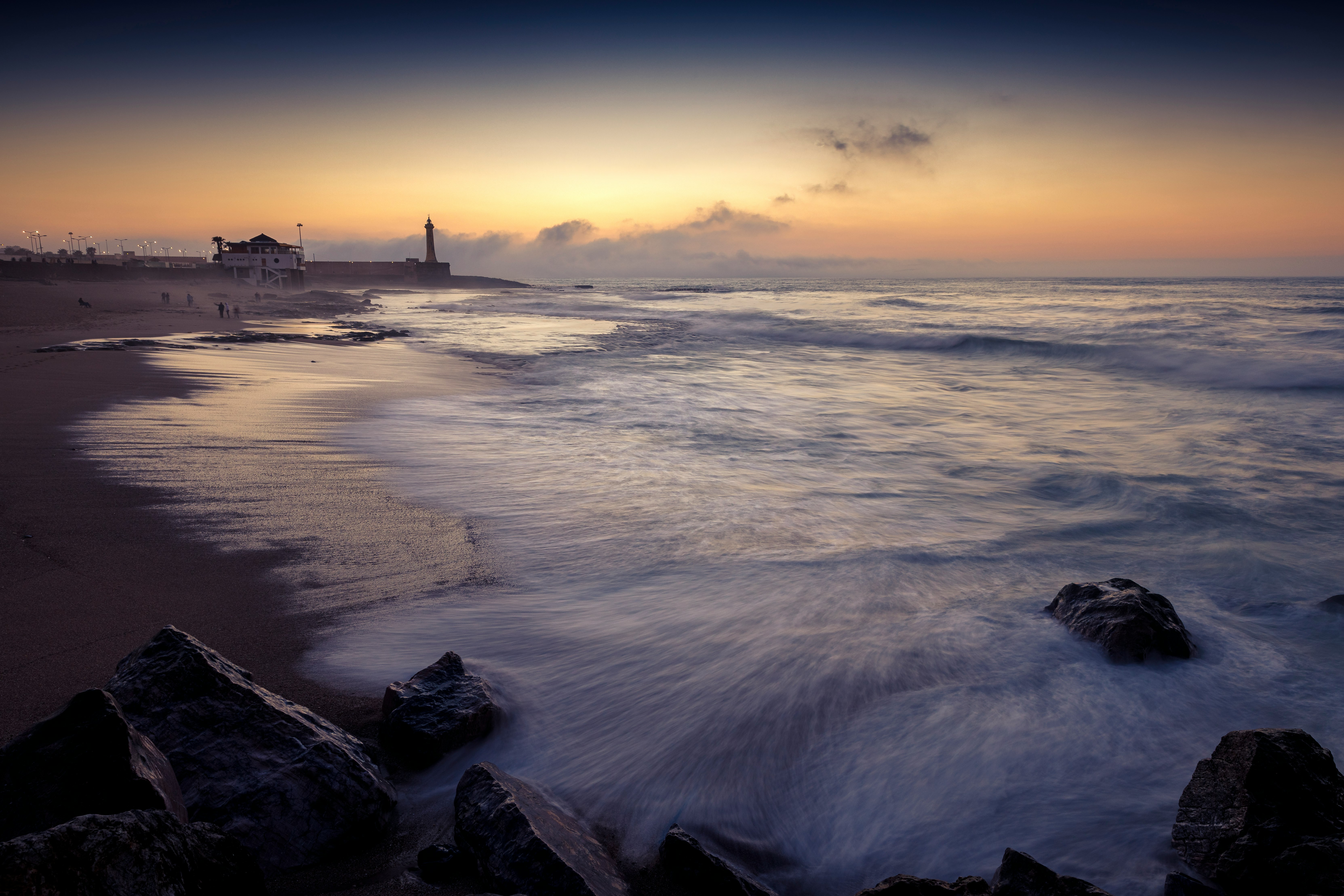 sea waves crashing on shore during sunset